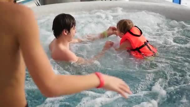 Man baadt de happy baby in het bad met whirlpool — Stockvideo