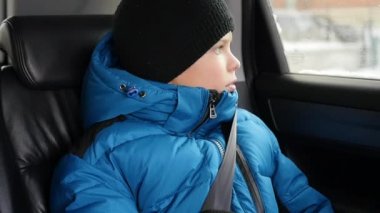 Çocuk arka koltuğa ve pencereden dışarı bakıp arabada rides