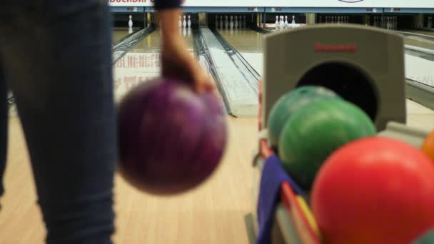 Dívka hází míč v bowlingu. 4k