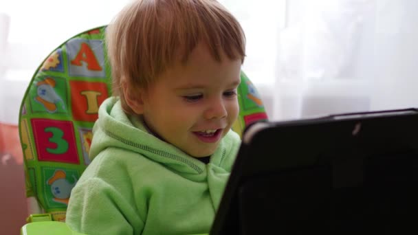 Heureux enfant regarder des dessins animés sur la tablette et souriant — Video