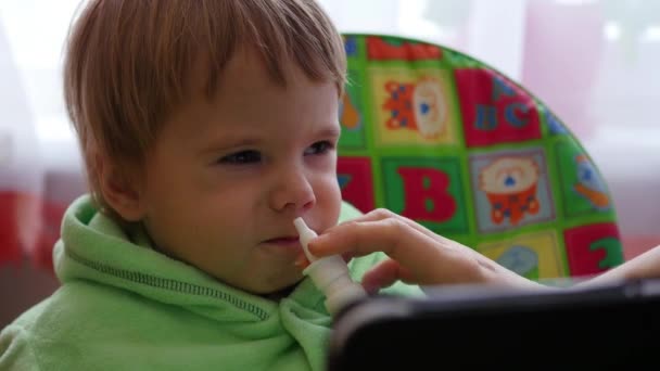 Barn splatter medicinering i näsan — Stockvideo