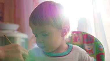 mutlu bir çocuk güneş ışığında bir fırçayla çizer