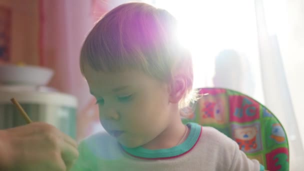 Een gelukkige kinderen tekent met een penseel op de zon — Stockvideo