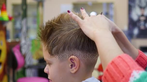 Corte de pelo de un niño con tijeras en la peluquería — Vídeos de Stock