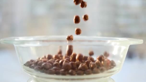 Corn balls with chocolate flavor slowly falling into a bowl. Slow Motion — Stock Video