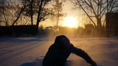 Çocuk atma kendini kar ve kış parkta günbatımında beğenir