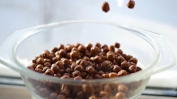 Bolas de milho com sabor de chocolate caindo lentamente em uma tigela. Movimento lento — Vídeo de Stock