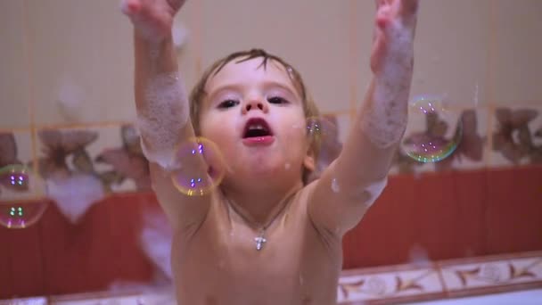 Ребенок играет с мыльными пузырями в ванной комнате — стоковое видео