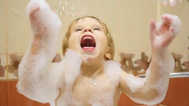 Enfant jouant avec des bulles de savon dans la salle de bain — Video