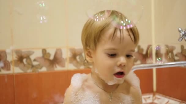 Enfant jouant avec des bulles de savon dans la salle de bain — Video