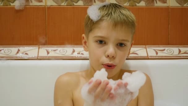 Niño se divierte jugando con espuma en el baño — Vídeos de Stock