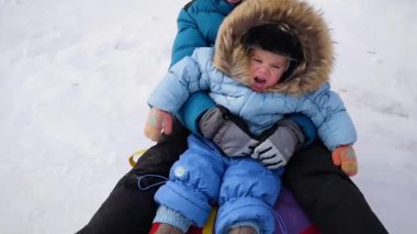 mutlu çocuklar rides ve snowtube içinde karlı bir tepeye düşüyor