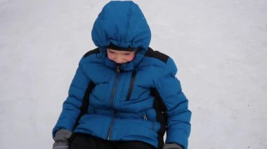 mutlu bir çocuğun sürmek ve snowtube içinde karlı bir tepeye düşüyor