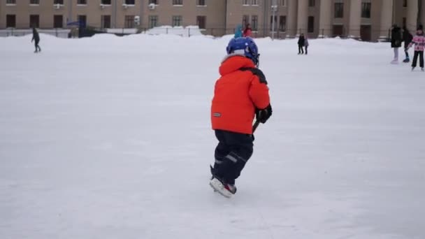 NOVOSIBIRSK, RUSIA - 27 DE NOVIEMBRE: un niño pequeño juega hockey en la pista de hielo — Vídeo de stock