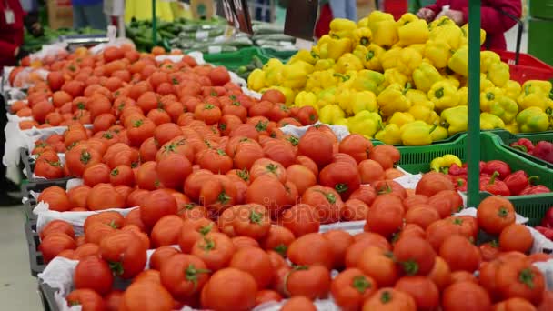 İnsanlar süpermarkette sebze domates seçer — Stok video