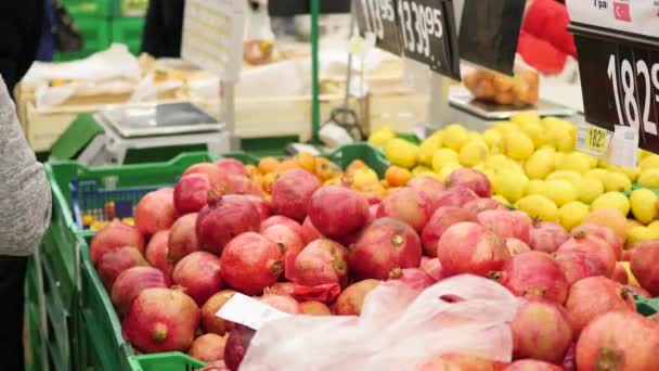Uma pessoa escolhe um fruto de granadas no supermercado — Vídeo de Stock