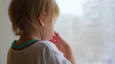 pencere ve pencere portre arayan bir çocuk duruyor