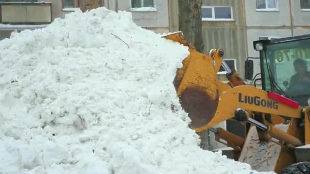 NOVOSIBIRSK, RUSIA - 7 de diciembre de 2016: el soplador de nieve elimina la nieve de la carretera en el patio — Vídeos de Stock