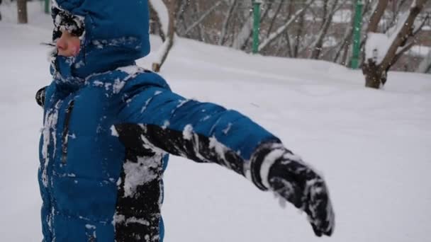 スローモーションで雪の中での子供の秋。雪の嵐 — ストック動画