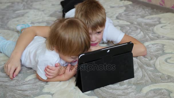 Kinder schauen Cartoons auf Tablet-PC am Boden — Stockvideo