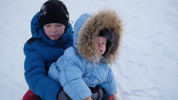 En glad barn rider och leende i snowtube på snötäckta vägar — Stockvideo