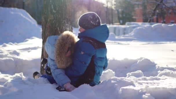 Ευτυχισμένα παιδιά διασκεδάζουν στο χειμερινό πάρκο μια ηλιόλουστη ημέρα — Αρχείο Βίντεο