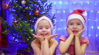 İki gülümseyen kız sevimli ve Noel akşam dans. Arka plan, ışıklar ve Noel köknar çelenk
