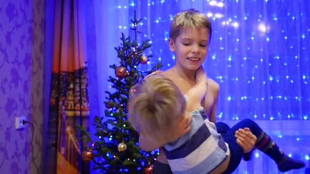 Le frère tourne le petit frère dans ses bras — Video