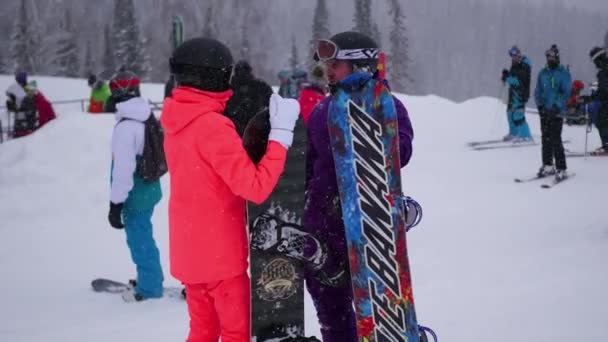 SHEREGESH, RÚSSIA - 24 de dezembro de 2016: um grupo de pessoas em uma estância de esqui na queda de neve — Vídeo de Stock