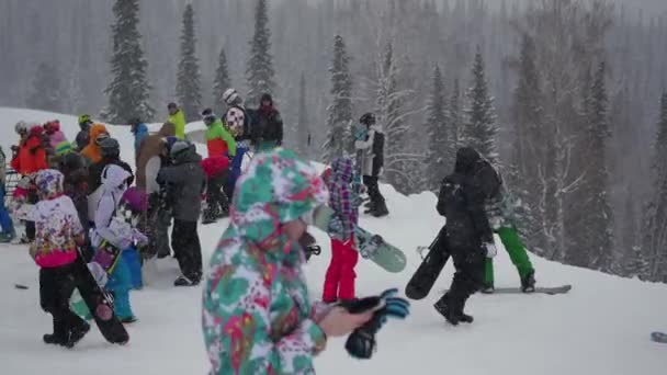 SHEREGESH, RÚSSIA - 24 de dezembro de 2016: um grupo de pessoas em uma estância de esqui na queda de neve — Vídeo de Stock