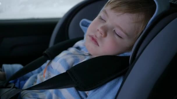 Barnet sover i bilen i vägen — Stockvideo