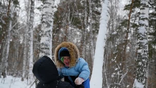 Guy speelt met baby in winter park. Werpt — Stockvideo