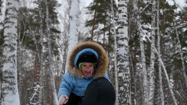 Guy παίζει με μωρό στο χειμερινό πάρκο. Ρίχνει επάνω — Αρχείο Βίντεο