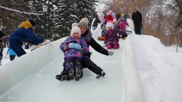 子供たちは氷のスライドで楽しんでいます. — ストック動画