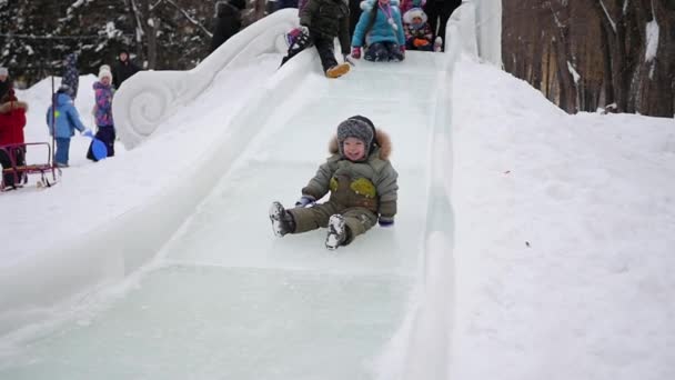 Children have fun on the ice slide. — Stock Video