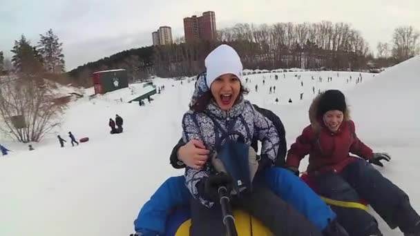 Passeios familiares felizes e sorrindo tubo de neve em estradas nevadas — Vídeo de Stock