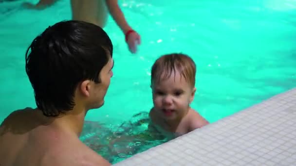 Der Typ, der dem Baby ein Bad im Pool gibt — Stockvideo