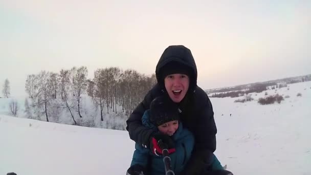 幸せな家族の乗り物と雪道に笑顔 snowtube — ストック動画