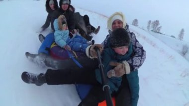 mutlu aile rides ve karlı yollarda gülümseyen snowtube