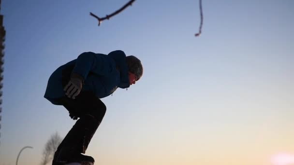 Adolescent joue sur le terrain de jeu en hiver. flips dans la neige au coucher du soleil — Video