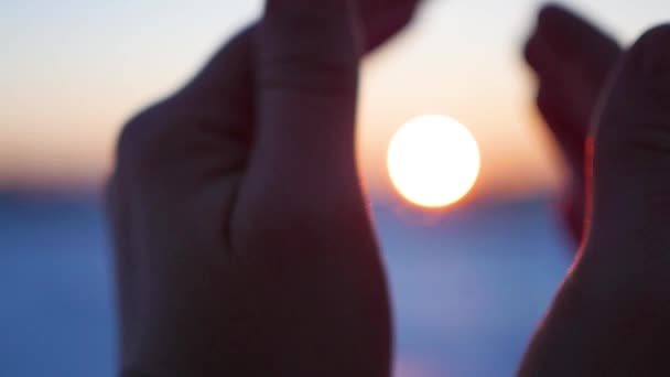Die Sonne in seinen Händen. Frau Hand, um die Sonne auf dem Hintergrund des schönen Sonnenuntergangs am Horizont zu fangen. Natur. — Stockvideo