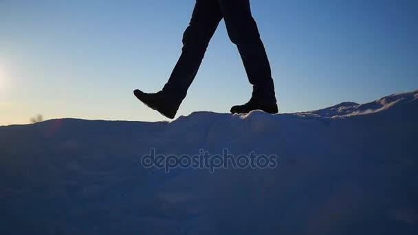 El tipo está en una pendiente de nieve y levanta las manos al atardecer. Nieve paisaje de invierno. deportes al aire libre — Vídeo de stock
