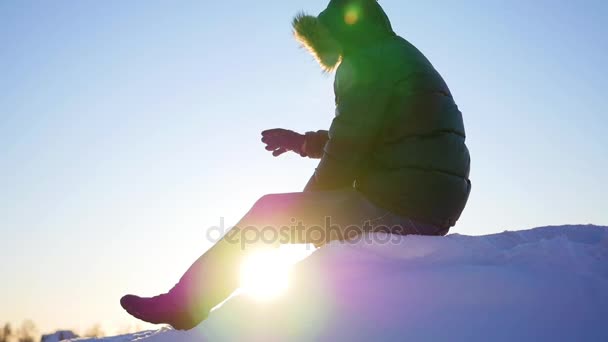 El tipo sentado en lo alto de una pendiente de nieve y saludando. nieve invierno paisaje. deportes al aire libre — Vídeos de Stock