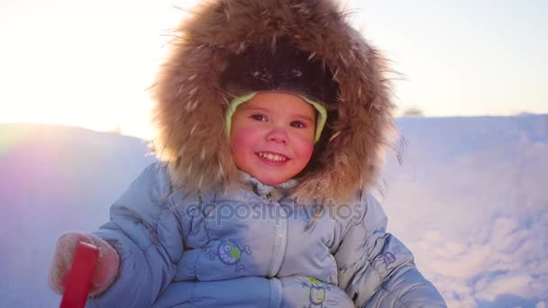 Gelukkig kind met plezier lachen in winter park op een zonnige dag. sneeuw winterlandschap. buitenshuis — Stockvideo