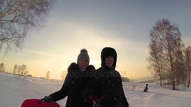 De familie stijgt tot besneeuwde heuvel. sneeuw winterlandschap. Zonsondergang tijd — Stockvideo