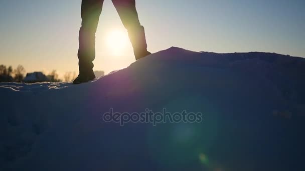 O cara está em uma inclinação de neve e levanta as mãos para cima no pôr do sol. esportes ao ar livre — Vídeo de Stock