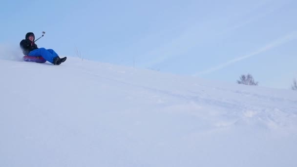 Lycklig kille Rider och leende snowtube på snöiga roads.slow rörelse. snö vinterlandskap. utomhus sport — Stockvideo