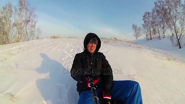 Cara feliz passeios e sorrindo tubo de neve em snowy roads.slow movimento. neve paisagem de inverno. esportes ao ar livre — Vídeo de Stock