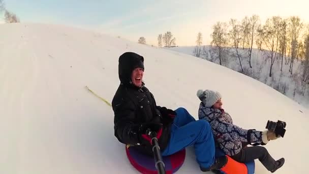 幸せな家族の乗り物と雪に覆われた roads.slow モーションに笑顔 snowtube。雪の冬の風景。アウトドア スポーツ — ストック動画