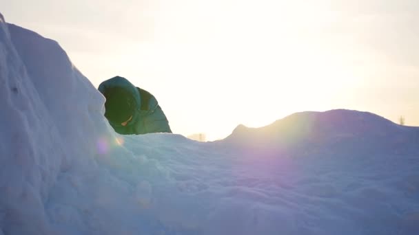 Criança brincando em montanhas nevadas, para subir ao topo. Ao pôr do sol — Vídeo de Stock